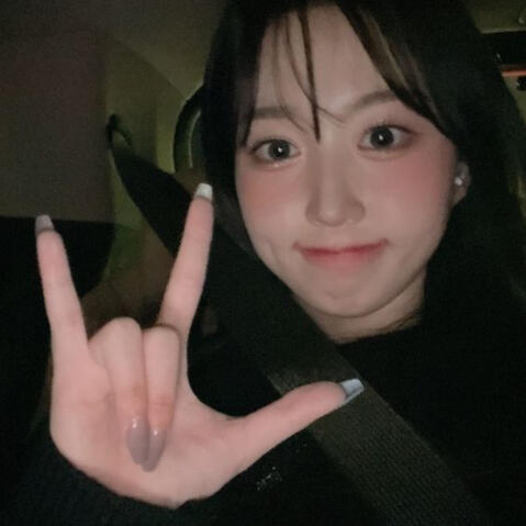 Haewon making an I love you Sign in ASL