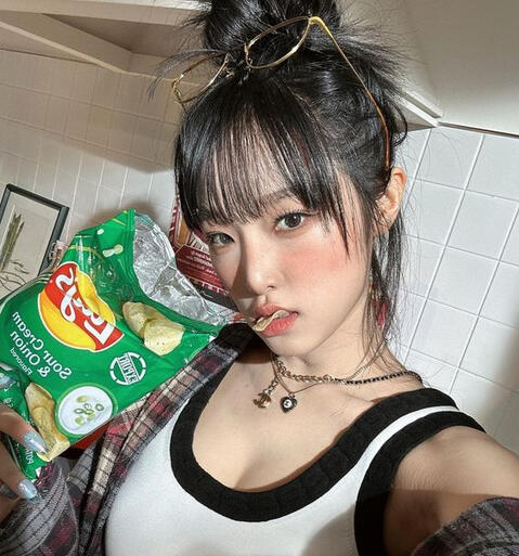 YENA the soloist holding Sour Cream and Onion Lays